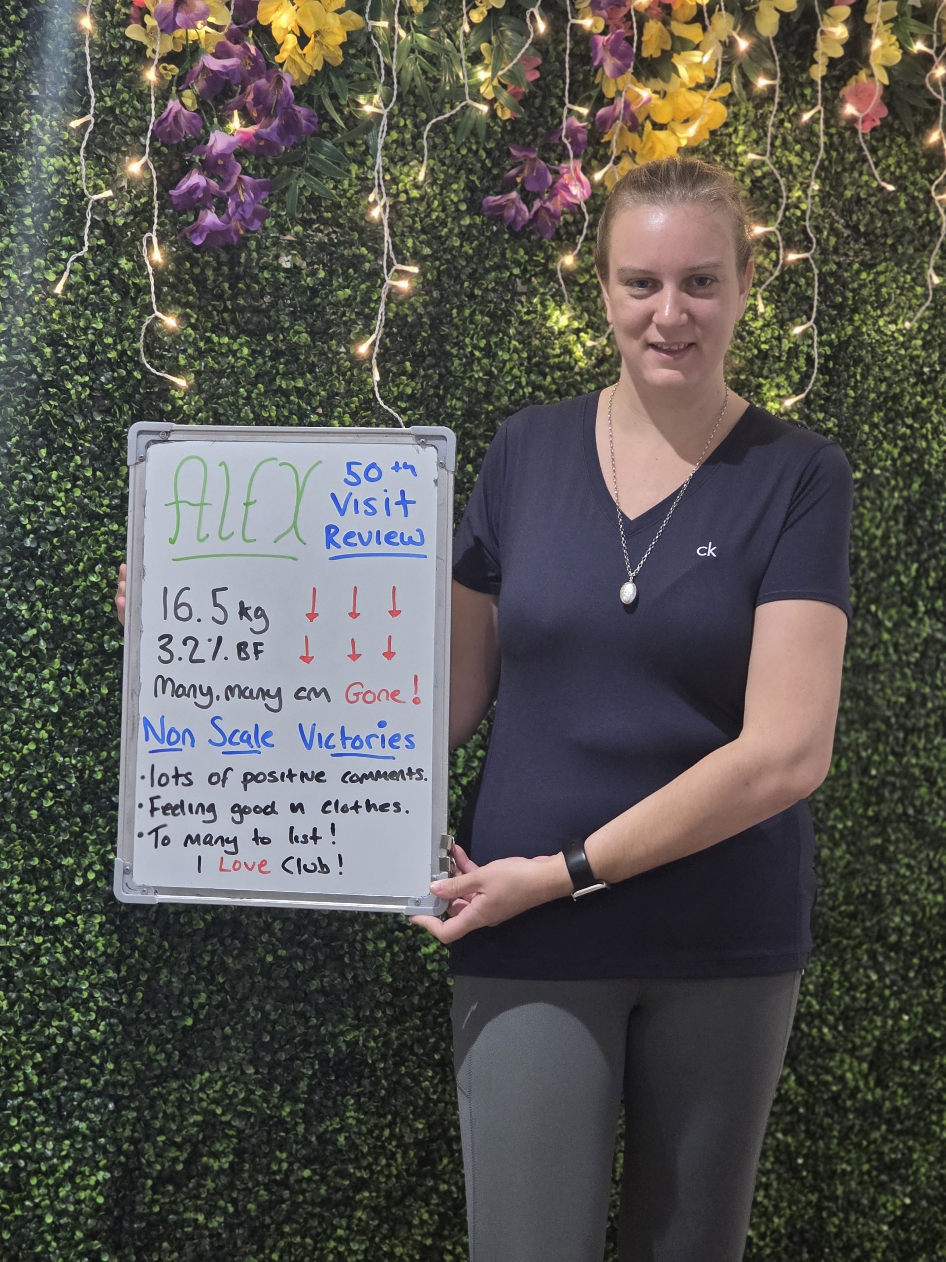 Alex holding her 50th-visit review board showing 16.5 kg lost at Eastbourne Nutrition